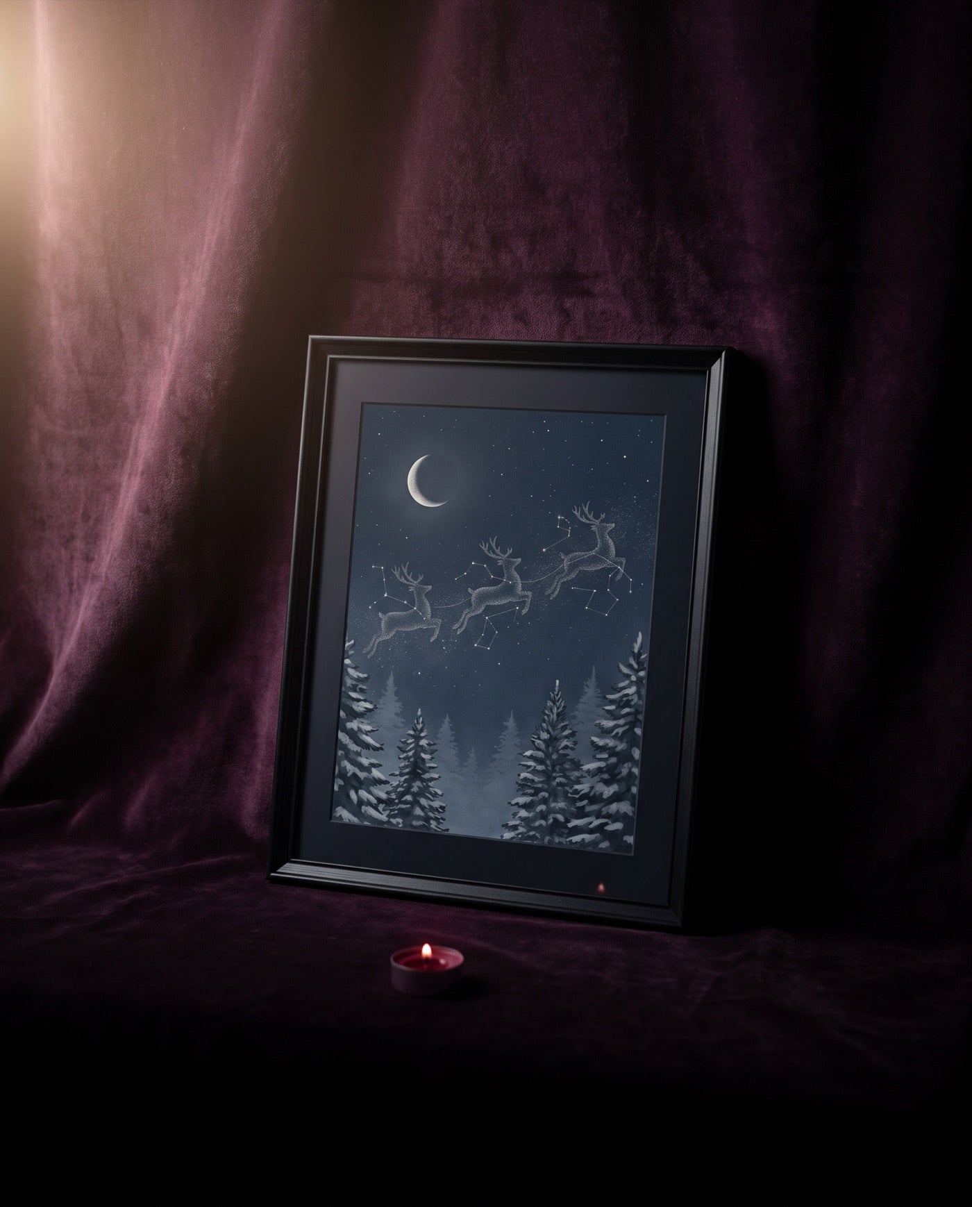 A framed winter print of reindeer made of stars, leaning on dark velvet beside a single candle